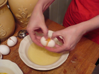 cracking an egg into the bowl